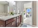 Bathroom featuring double sinks and a vanity, opening up to the main bedroom at 341 Thistlewood Dr, Greenfield, IN 46140