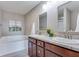Bright bathroom featuring double sinks, a granite countertop, and a soaking tub at 341 Thistlewood Dr, Greenfield, IN 46140