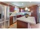 Well-lit kitchen with stainless steel appliances, wood cabinets, and stylish island at 341 Thistlewood Dr, Greenfield, IN 46140