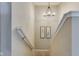 Carpeted stairs with decorative lighting and wood handrails at 341 Thistlewood Dr, Greenfield, IN 46140