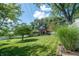 View of home from grassy backyard with retaining wall and trees at 37 E Waterbury Rd, Indianapolis, IN 46227