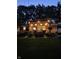 Outdoor deck area with string lights and lush landscaping in the backyard at night at 37 E Waterbury Rd, Indianapolis, IN 46227