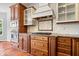Close up of gourmet kitchen featuring a gas cooktop, custom hood and tile backsplash at 3711 Pete Dye Blvd, Carmel, IN 46033