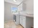 Efficient laundry room features a modern washer and dryer, plus ample cabinet and counter space at 3711 Pete Dye Blvd, Carmel, IN 46033
