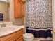 Cozy bathroom with wood cabinets, granite countertop, patterned shower curtain, and white toilet at 3903 Junco Cir, Indianapolis, IN 46228
