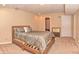 Well-lit bedroom featuring a wooden bed frame, stylish bedding, and neutral carpet at 3903 Junco Cir, Indianapolis, IN 46228