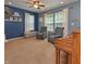 Comfortable living room with blue walls, neutral carpet, and bright natural light streaming through large windows at 3903 Junco Cir, Indianapolis, IN 46228