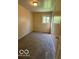 Standard bedroom with tan carpet, a window, and paneled walls at 4014 Arquette Dr, Indianapolis, IN 46235