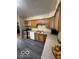 Well-lit kitchen boasts neutral countertops, modern appliances, natural wood cabinets, and gray LVP flooring at 4014 Arquette Dr, Indianapolis, IN 46235