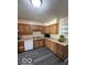 Bright kitchen features neutral countertops, wood cabinetry, modern appliances, and luxury vinyl plank flooring at 4014 Arquette Dr, Indianapolis, IN 46235
