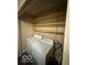 A small laundry room with a side-by-side washer and dryer and shelving for storage at 4014 Arquette Dr, Indianapolis, IN 46235