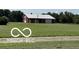Large barn with red and white exterior, set amidst a sprawling green field at 4680 Cartersburg Rd, Plainfield, IN 46168