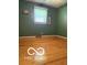 Cozy bedroom featuring hardwood floors, natural light from the window, and charming decor at 4680 Cartersburg Rd, Plainfield, IN 46168
