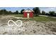 Charming outbuilding with a red exterior and white trim, offering versatile space on a gravel lot at 4680 Cartersburg Rd, Plainfield, IN 46168