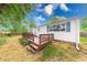 Home's backyard featuring a raised deck and a fenced yard with mature trees at 5512 Lunsford Dr, Indianapolis, IN 46237