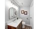Bathroom features a wood vanity with light countertops, decorative mirror, and neutral paint at 5512 Lunsford Dr, Indianapolis, IN 46237