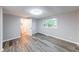 Bedroom with gray walls and wood-look floors features a window overlooking the backyard at 5512 Lunsford Dr, Indianapolis, IN 46237