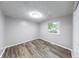 Minimalist bedroom with wood-look flooring, neutral paint and closet with white doors at 5512 Lunsford Dr, Indianapolis, IN 46237