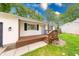 A welcoming front porch with stained wood decking, a light blue front door, and beautiful landscaping at 5512 Lunsford Dr, Indianapolis, IN 46237