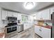 Bright and modern kitchen with stainless steel appliances and a view to the backyard at 5512 Lunsford Dr, Indianapolis, IN 46237