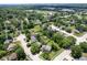 Overhead view of a suburban neighborhood featuring lush green trees, residential homes, and a glimpse of a pond at 5640 Dapple Ct, Indianapolis, IN 46228