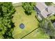 Aerial view of the backyard with lush green grass, tall trees, and recreational equipment for outdoor enjoyment at 5640 Dapple Ct, Indianapolis, IN 46228
