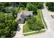 An aerial view shows the house, driveway, mature trees and fenced backyard with trampoline at 5640 Dapple Ct, Indianapolis, IN 46228
