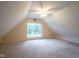Finished attic featuring carpet and a window with a large shade tree outside at 5640 Dapple Ct, Indianapolis, IN 46228