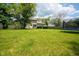 Large backyard with green lawn, wooden fence, mature trees, and recreational equipment, creating a private outdoor space at 5640 Dapple Ct, Indianapolis, IN 46228