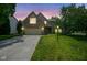 Charming brick two-story home with well-maintained lawn and attached two car garage at twilight at 5640 Dapple Ct, Indianapolis, IN 46228