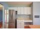 Kitchen with stainless steel refrigerator, white cabinets, and built-in desk area at 5640 Dapple Ct, Indianapolis, IN 46228