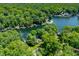 An aerial view of a lakefront property showcases a tree-lined shore and private boat docks at 6254 Grosbeak Ct, Nineveh, IN 46164