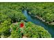 An aerial view shows a property among dense trees on a lake with docks at 6254 Grosbeak Ct, Nineveh, IN 46164