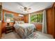 Bright bedroom with wood paneling, ceiling fan, and large windows offering wooded views at 6254 Grosbeak Ct, Nineveh, IN 46164