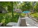 View of the home and deck with a sun umbrella and lush greenery, showing its serene outdoor space at 6254 Grosbeak Ct, Nineveh, IN 46164