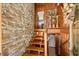 Unique foyer with a stone accent wall and rustic wooden staircase leading to the upper level at 6254 Grosbeak Ct, Nineveh, IN 46164