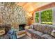 Inviting living room with a stone fireplace, wood paneling, and ample natural light through the window at 6254 Grosbeak Ct, Nineveh, IN 46164