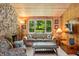 Cozy living room featuring a stone fireplace, wood paneling, and a comfortable sofa at 6254 Grosbeak Ct, Nineveh, IN 46164