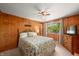 Cozy main bedroom with wood paneling, a ceiling fan, and a view of the lake from the window at 6254 Grosbeak Ct, Nineveh, IN 46164