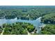 Waterfront homes with private docks dot the shoreline in this aerial view of a serene lake surrounded by dense trees at 6300 Grouse Dr, Nineveh, IN 46164