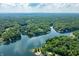 Lush aerial view showing a serene lake surrounded by homes and dense green forest at 6300 Grouse Dr, Nineveh, IN 46164