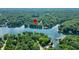 A waterfront property is highlighted in this aerial view, with lush trees and a tranquil lake surrounding it at 6300 Grouse Dr, Nineveh, IN 46164