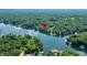 An aerial view showcases a waterfront property with a pin marker, nestled among lush trees and a tranquil lake at 6300 Grouse Dr, Nineveh, IN 46164