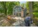 Home's lakeside backyard features patio, stairs, and brick and siding exterior at 6300 Grouse Dr, Nineveh, IN 46164