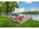 Lakeside retreat with dock, fire pit area, and trees surrounding property at 6300 Grouse Dr, Nineveh, IN 46164