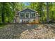 Home's rear exterior shows large windows, brick accents, and scenic backyard at 6300 Grouse Dr, Nineveh, IN 46164