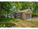 View of a house with gray siding, a brick garage, and mature trees surrounding the property at 6300 Grouse Dr, Nineveh, IN 46164
