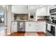 Well-lit kitchen with white cabinets, stainless steel appliances and view to living space at 6300 Grouse Dr, Nineveh, IN 46164