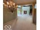Elegant living space featuring a decorative chandelier, columns, and large window at 8577 One W Dr # 301, Indianapolis, IN 46260