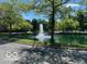 Community pond with a central water fountain feature surrounded by mature trees at 8577 One W Dr # 301, Indianapolis, IN 46260
